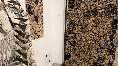 Schneiderpuppe vor einem abstrakten Bild in Gold Schwarz