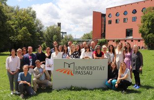 Symposium participants with University Passau sign in front of Philosophicum