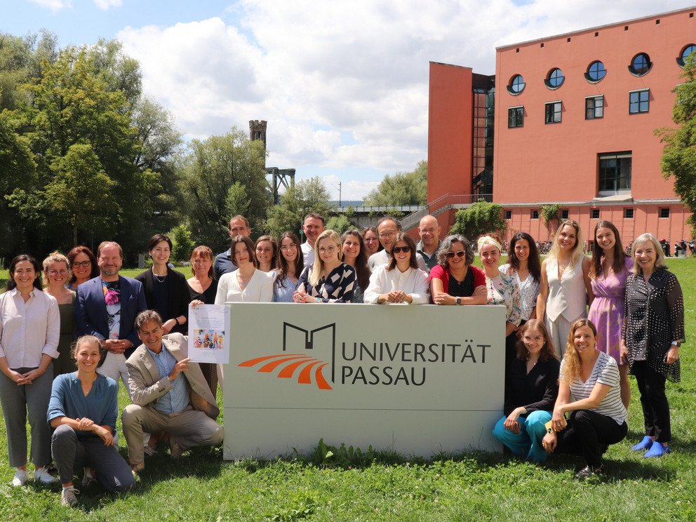 Symposium participants with University Passau sign in front of Philosophicum