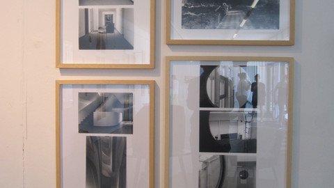 Gerahmte Fotografien an einer Wand h&auml;ngend