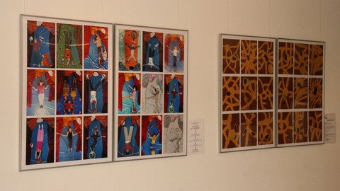 Bilder gerahmt an der Wand Menschen vor rotem Hintergrund