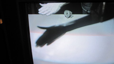 Hand wirft einen Schatten auf eine wei&szlig;e Oberfl&auml;che