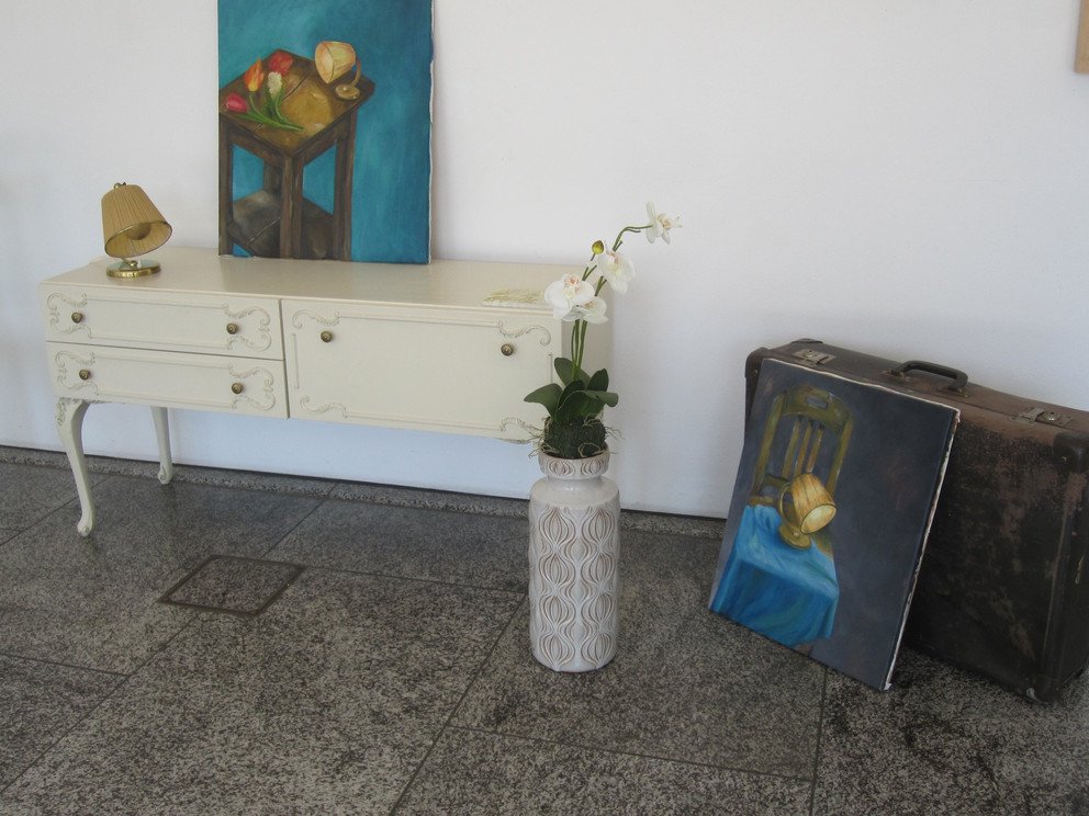 Kommode mit Bild neben einem Koffer