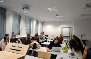 Studierende arbeiten in Gruppen im Seminarraum