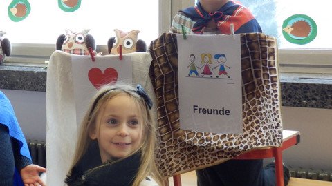 zwei Kinder mit einem Bild in der Hand, auf dem das "Freunde" steht