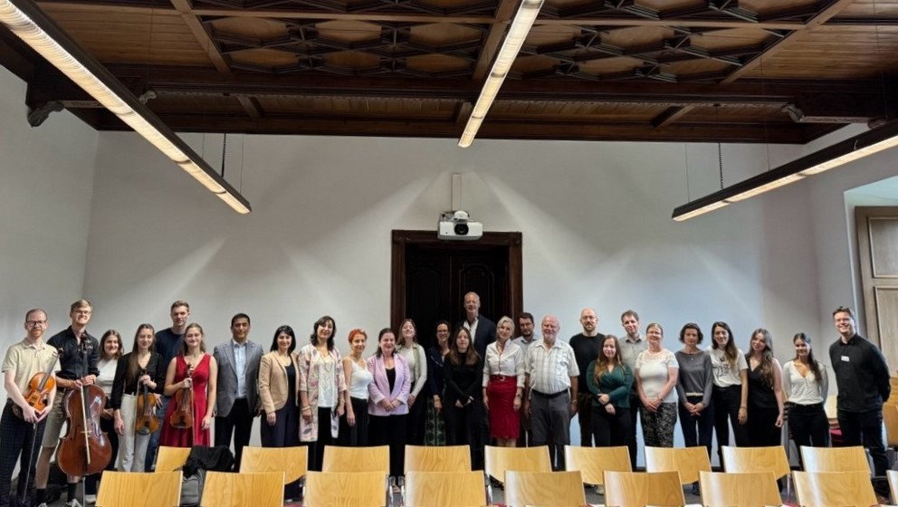 Fotohinweis: Fr&ouml;hliche Gesichter zur Er&ouml;ffnung des DAAD-Sommerseminars (von links): Mitglieder des Universit&auml;tsorchesters, Seminarteilnehmende, Prof. Dr. Julia Ricart Brede, Prof. Dr. Thomas W&uuml;nsch, Prof. Dr. Christina Hansen und Koordinator Danny Jurjevich (alle Universit&auml;t Passau). Foto: Karolina Windpassinger, Perspektive Osteuropa