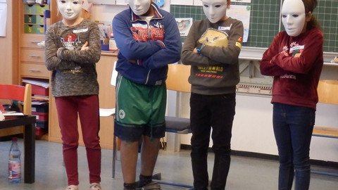 Vier Kinder mit wei&szlig;en Masken vor dem Gesicht