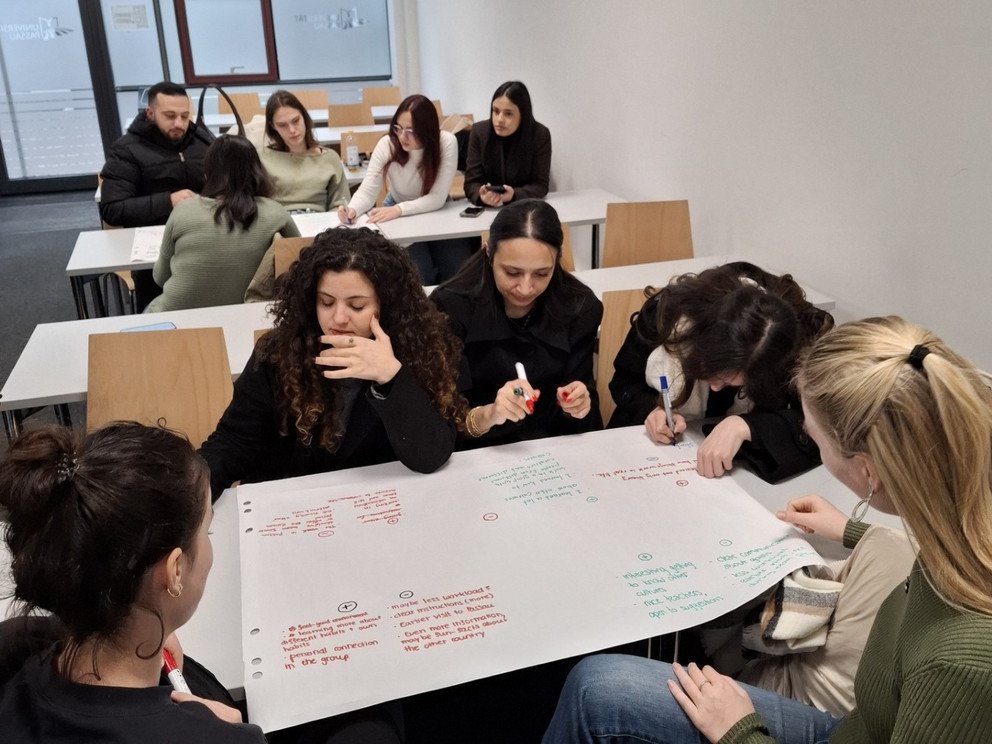 Students sitting in groups and working on flipcharts
