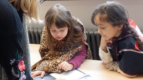Kinder schauen sich ein Buch an