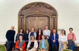 Participants in front of a wooden door inside the historical rooms of the symposium