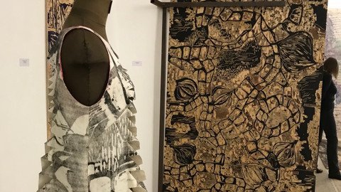 Schneiderpuppe vor einem abstrakten Bild in Gold Schwarz