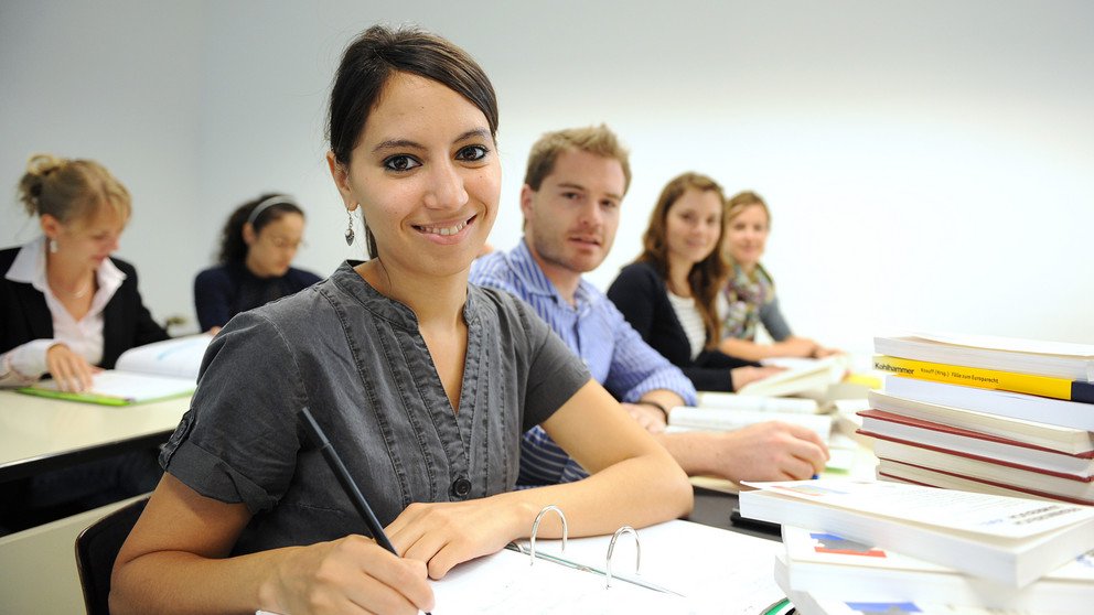 Foto zeigt Studierende mit B&uuml;chern