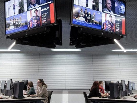 A computer room with large screens on the ceiling