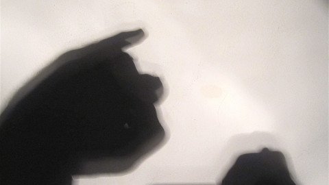 Schatten von H&auml;nden auf einer wei&szlig;en Oberfl&auml;che