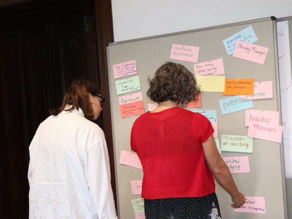 Two female participants working on a metaplan wall