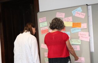 Two female participants working on a metaplan wall